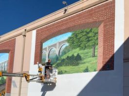 
			
				                                Bob Lizza works on the secondmural panel in the ‘Telling Wyoming County History Project’ at the Dietrich Theater. The mural can be viewed from the by-pass or in the theater’s parking lot.
 
			
		